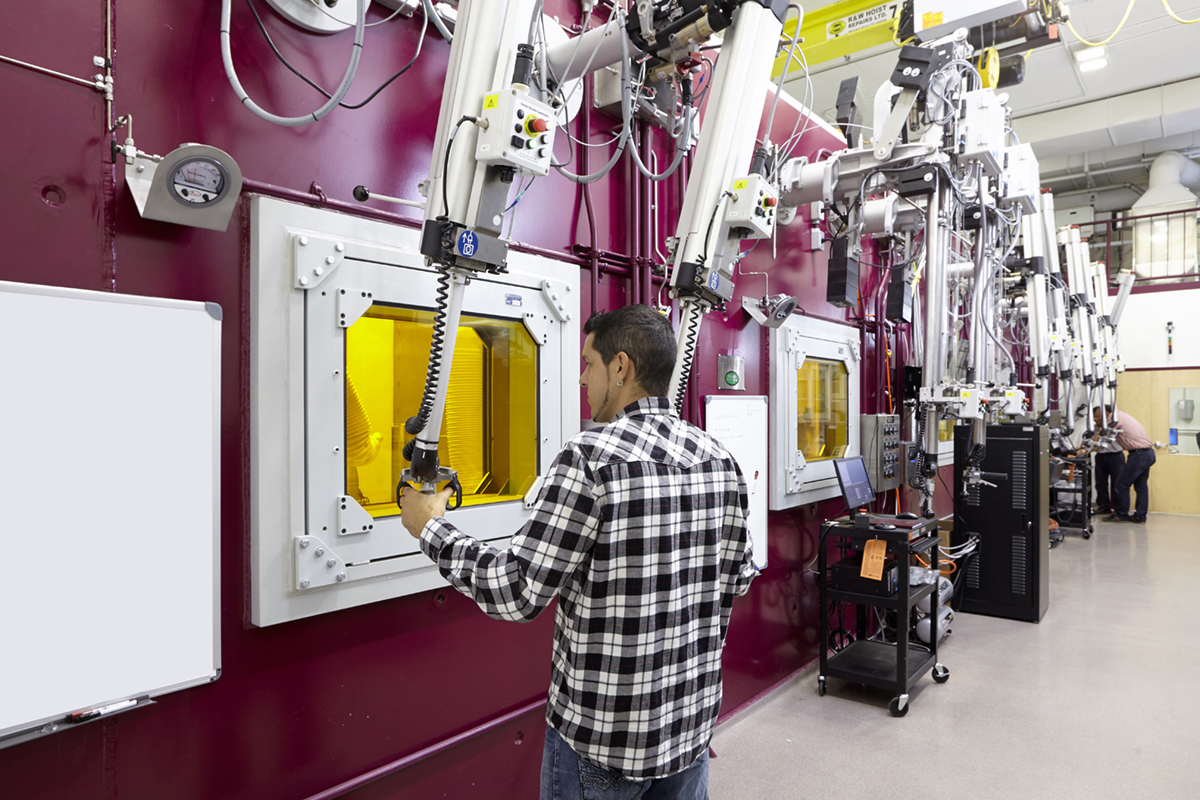 A researcher operates a hot cell's mechanical arms inside the Centre for Advanced Nuclear Systems.