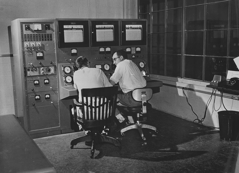 Reactor operators sit on chairs inside the control room.