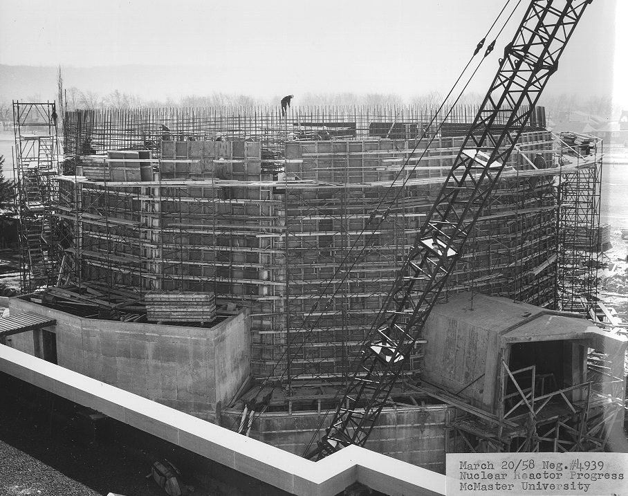 Construction of the McMaster Nuclear Reactor. A worker stands on the roof.