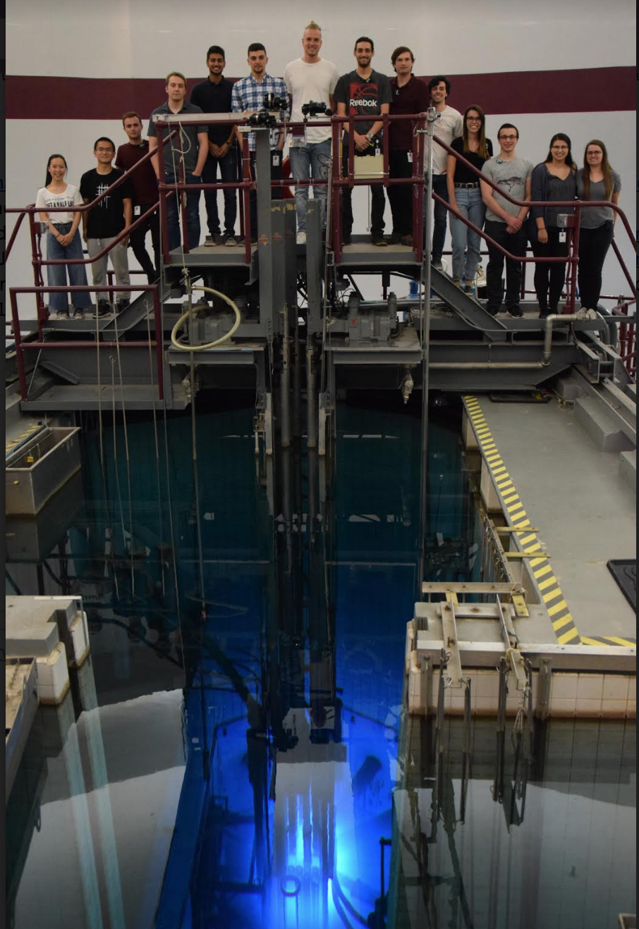 Summer students stand on bridge over the McMaster Nuclear Reactor.