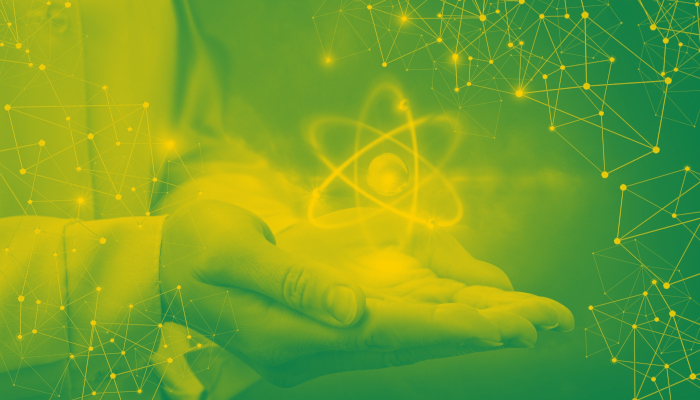 Decorative image of a person's hands holding an atom.