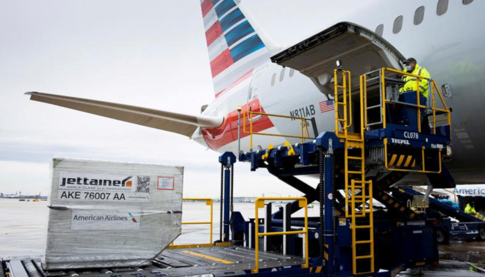 An airplane is being loaded with cargo on a runway.