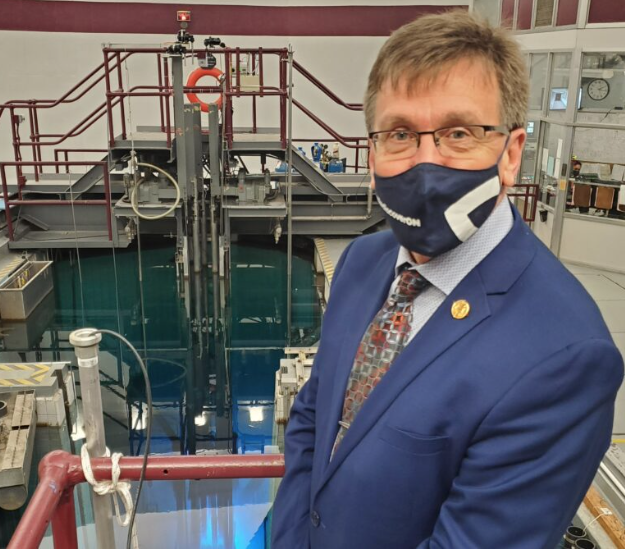 MPP Bill Walker standing in front of the reactor pool at McMaster Nuclear Reactor.