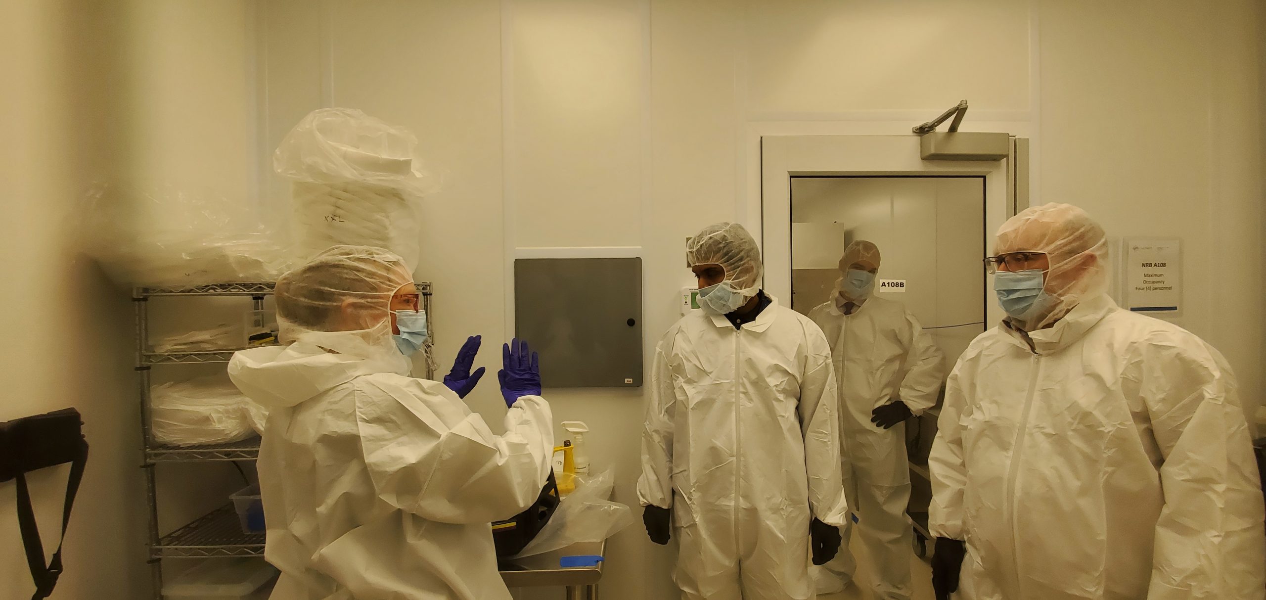 Inspectors wear personal protection equipment inside a laboratory at McMaster University.