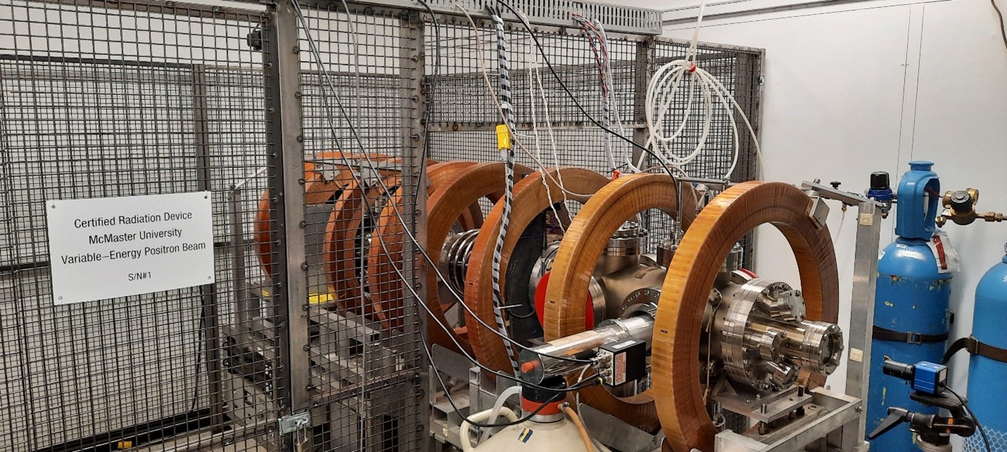 Positron beamline at TAB. A metal tube surrounded by copper rings inside metal cage.