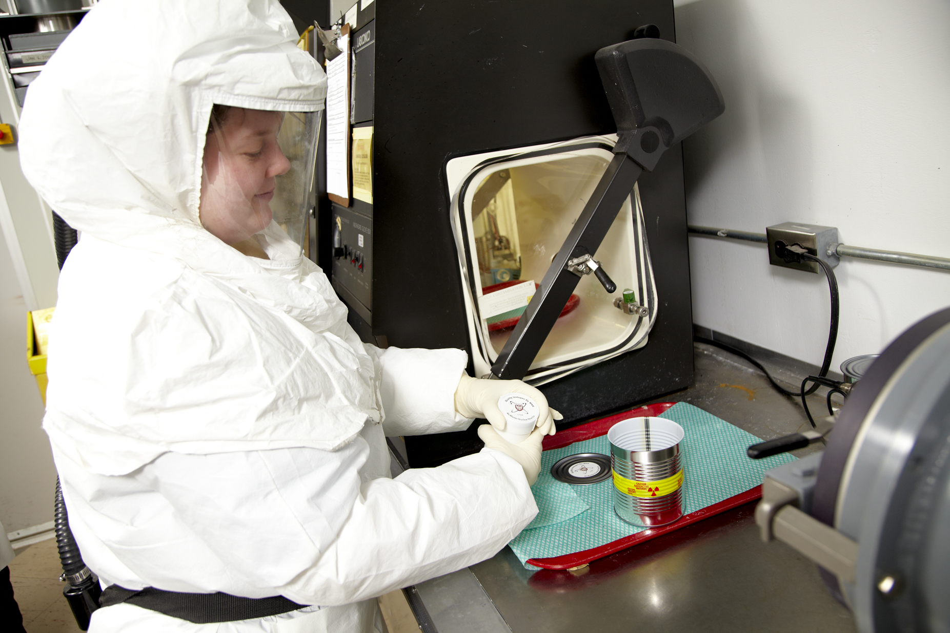 A technician wearing PPE preparing a medical isotope.