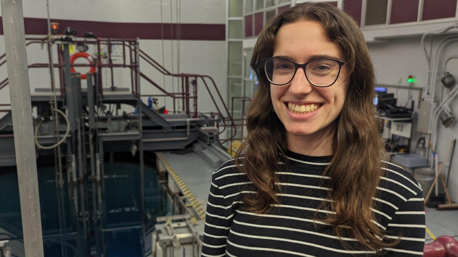 Beth Croome standing next to McMaster Nuclear Reactor.